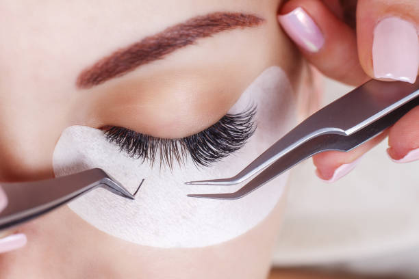 Eyelash Extension Procedure. Woman Eye with Long Eyelashes. Lashes. Close up, macro, selective focus